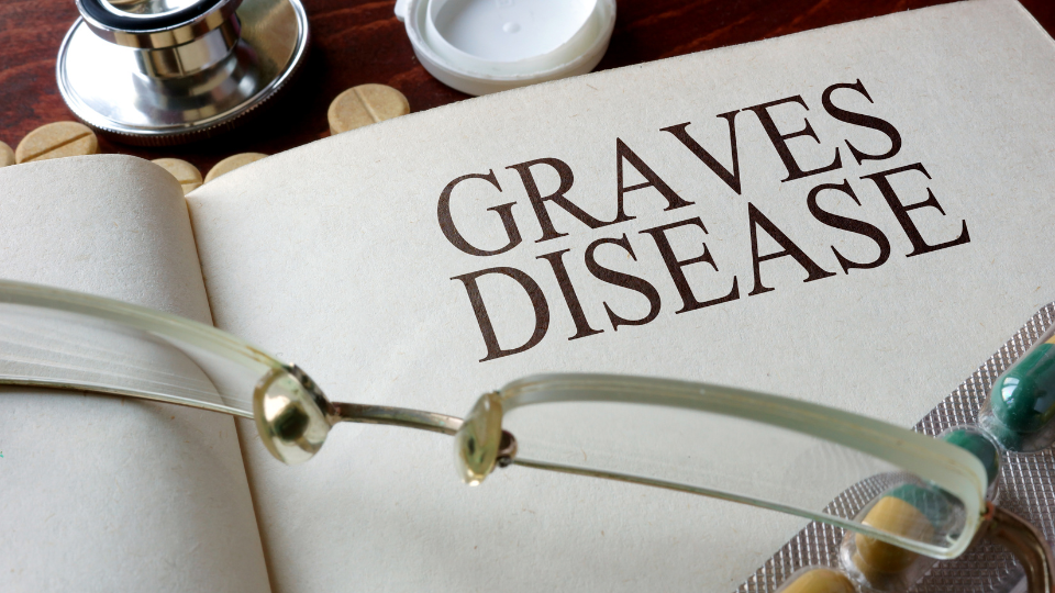 Otwarte medyczne notatki z napisem „Graves Disease”, okulary i stetoskop na stole